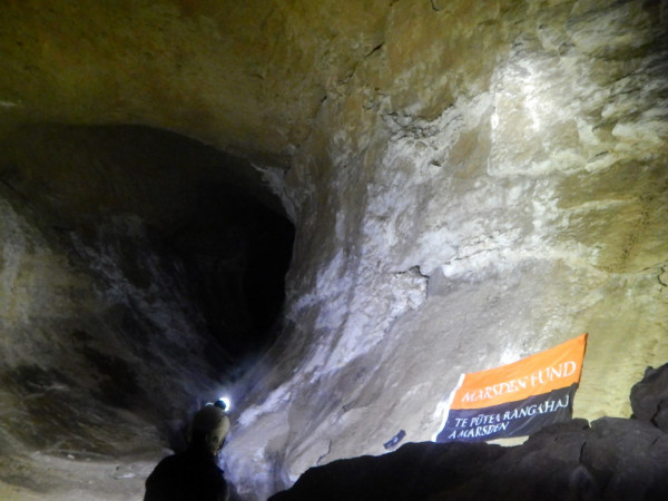 a man with a headtorch in a cave