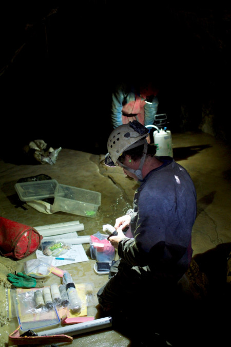 A scientist with samples in a cave