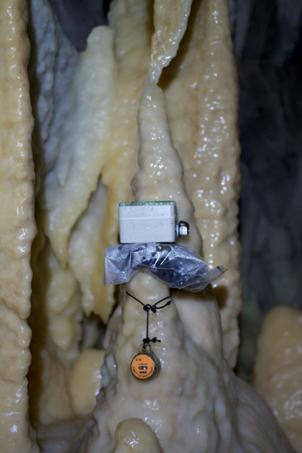 scientific equipment attached to a stalagmite in a cave